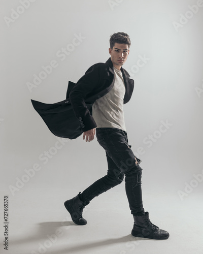 Принти на полотні sexy man walking to side with overcoat in the air