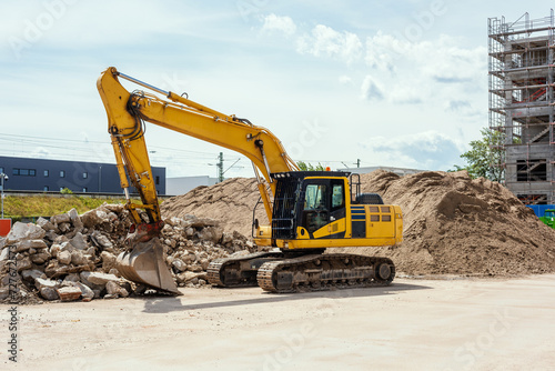 yellow excavator on a construction site. Also called diggers, JCB, mechanical shovels, or 360-degree excavators