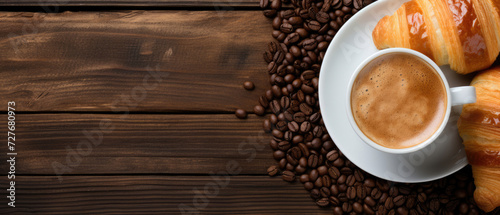 Croissants and a cup of coffee on a wooden table, flat lay. Horizontal banner. Copy space for text