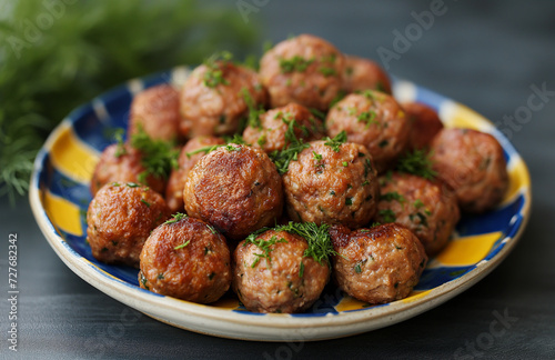 Golden brown Köttbullar, the famous meatballs, present themselves as a delicious delicacy on a traditional Swedish plate. The background of the plate reflects a Scandinavian design and Swedish colors. photo