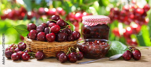 Cherry jam and fresh fruits on wooden table in a garden