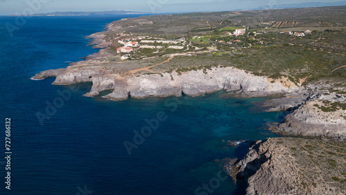 Aerial view of Cala Sapone, S. Antioco bay in Sardinia. Crystal clear sea, moored boat and white sand.