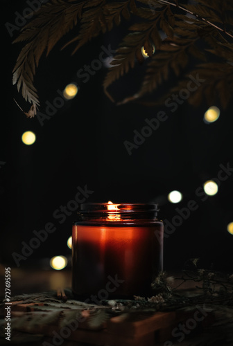 Lit aromatherapy candle with tropical vibes and leaves giving a calm and relaxing feeling