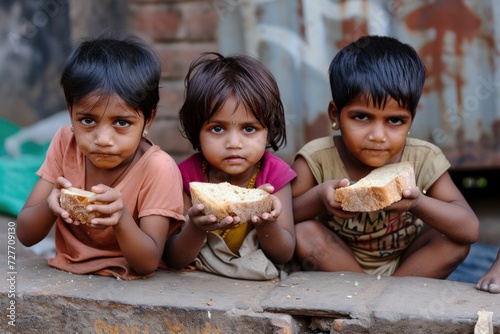 Poor Indian children eat bread on the street of Mumbai, Maharashtra photo