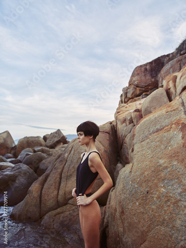 Seductive Summer: A Beautiful Woman in Sexy Swimwear Posing on a Rock, Enjoying Beach Paradise