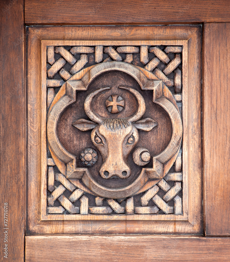 Wooden sculpture with an ox head on the door of Sihastria Putnei monastery - Romania. In the past it represented the emblem of Moldova