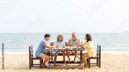 Happy Asian family enjoy and fun outdoor lifestyle travel nature and having dinner sea food at tropical beach on summer vacation. Adult couple and aging parents celebration holiday party together. © CandyRetriever 