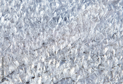 A macro shot with a layer of snow on the surface. Close-up with snowflake crystals