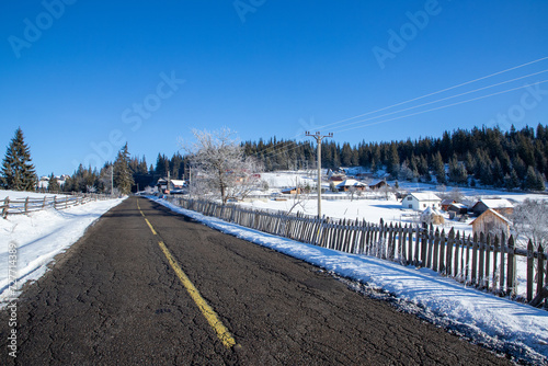 Landscape with traditional houses on the slope of a hill in Sadova village, Suceava county - Romania in winter photo