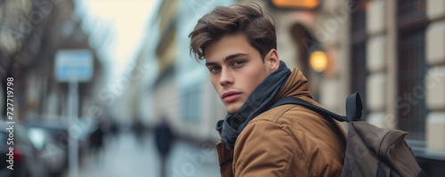 Trendy young man posing on street looking at camera