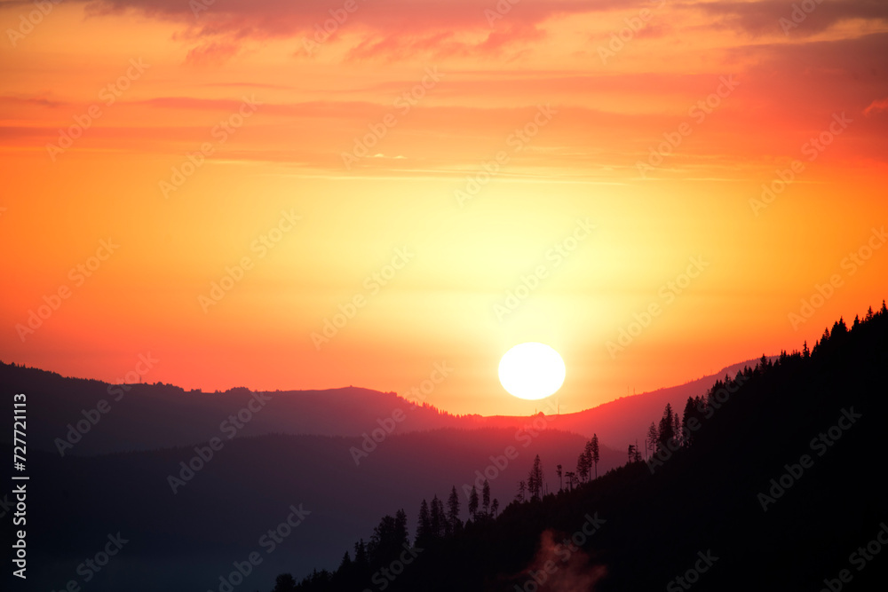 Silhouettes of mountain ranges and trees against the backdrop of the setting sun.
Silhouettes of mountain ranges and trees against the backdrop of the setting sun.