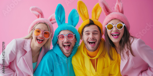 Happy easter!  Joyful Easter celebration with young people in colorful bunny ears and sunglasses against pink