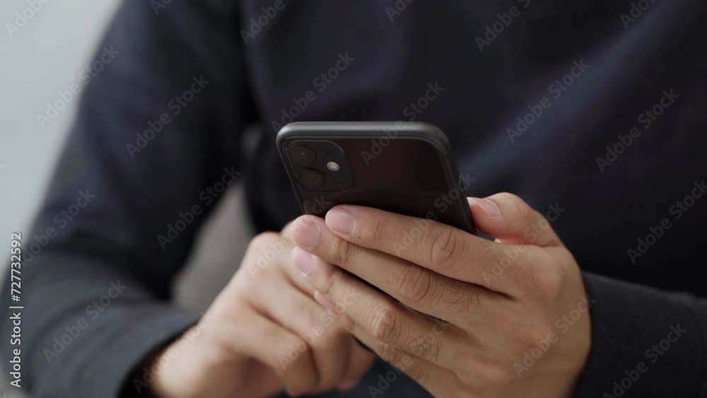 The young man's hand is using a smartphone to access the internet and searching for information, social network. The young man's hand is using a smartphone to access the internet and searching for information, social network.