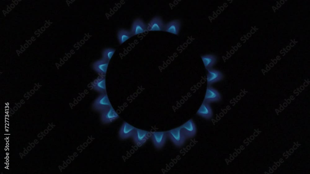 Burning natural gas on a gas stove. Small burner on a black background. From the moment of ignition to extinction.
