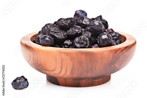 black raisin in wooden bowl on white background