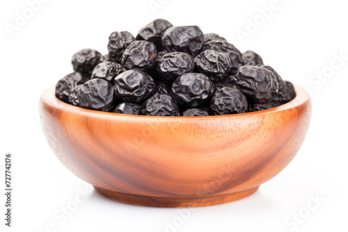 black raisin in wooden bowl on white background