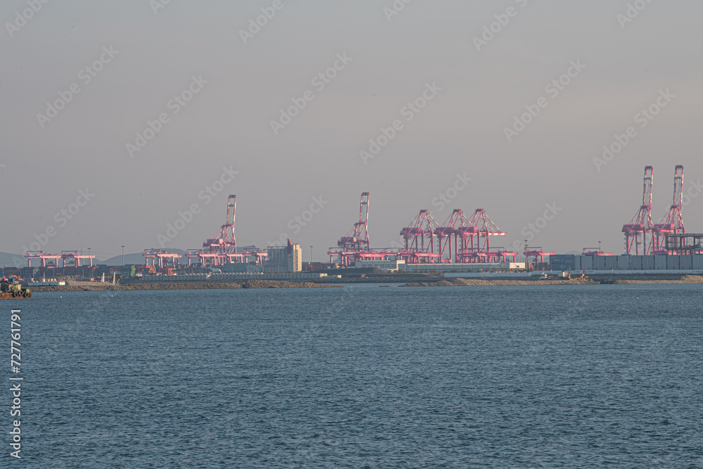 Cranes and sea transporting containers in port
