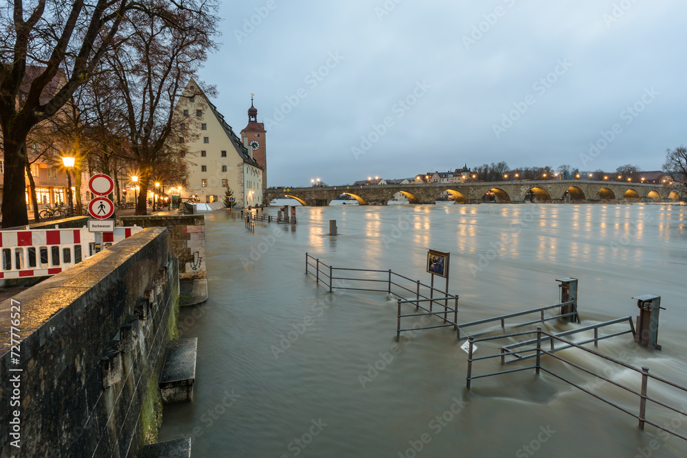 Regensburg, Steinerne Brücke,  im Dezember mit Hochwasser am Abend