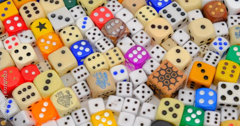 Rainbow coloured plastic dices on a rotating table Rainbow coloured plastic dices on a rotating table