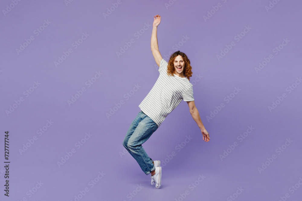 Full body side view young man he wear grey striped t-shirt casual clothes stand on toes leaning back with outstretched hands isolated on plain pastel light purple background studio. Lifestyle concept