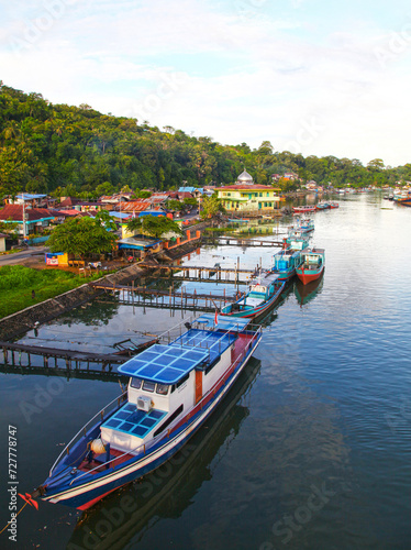 Colorful blue and red fishing boats in the Batang Arau river and port in Padang City in West Sumatra, Indonesia.