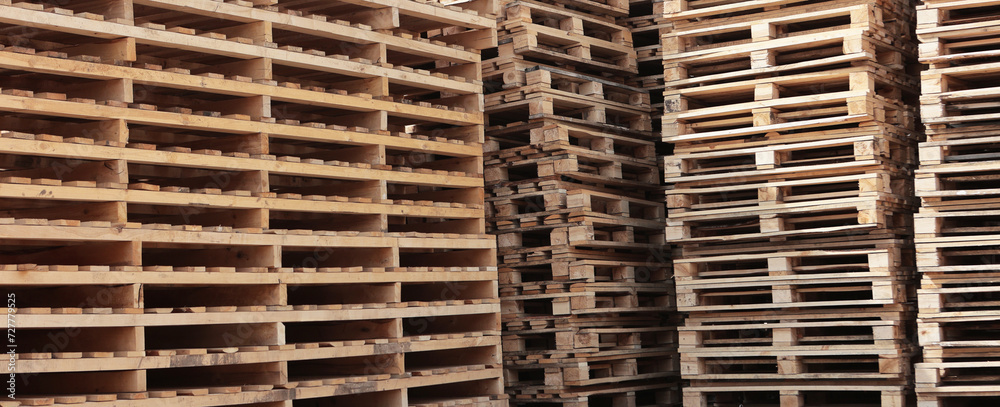 Wooden pallets for transportation of building materials. Stacking of wooden pallets. Concept of cargo transportation and shipping.Narrow banner. Wooden pallets for transportation of building materials. Stacking of wooden pallets. Concept of cargo transportation and shipping.Narrow banner.