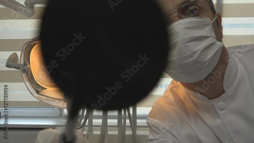 POV portrait of dentist working on patient teeth photo