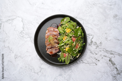 Salad with duck breast, arugula leaves, orange, crushed walnuts