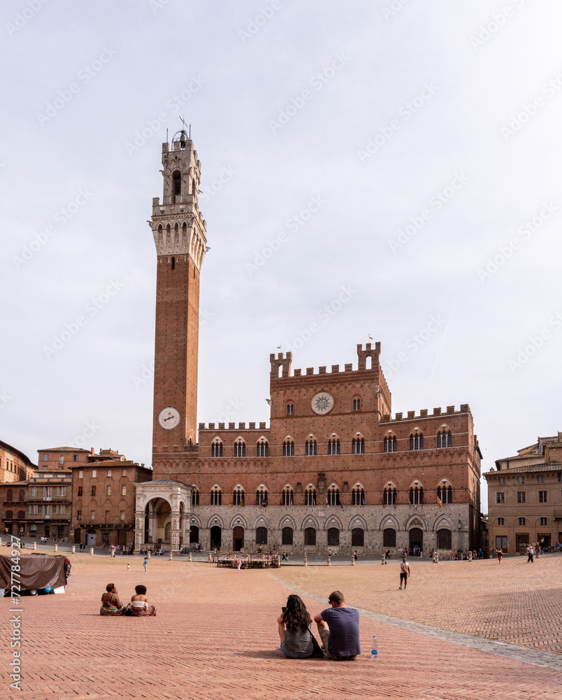Fototapeta premium SIENA, ITALY - SEPTEMBER 23, 2023 - The iconic Palazzo Pubblico at the Piazza del Campo in downtown Siena