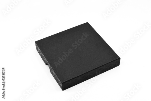 Small square black gift box isolated on a plain white background. Copy space. No people.