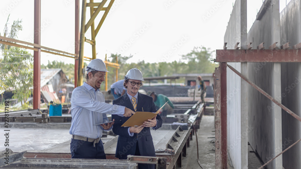 Factory owner discusses with his engineer to design for a new construction product. Supervisor provides technical advice to his manager in a factory Factory owner discusses with his engineer to design for a new construction product. Supervisor provides technical advice to his manager in a factory