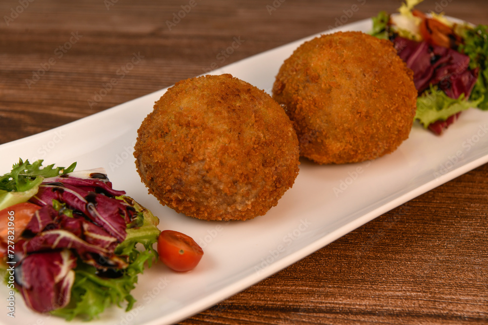 RECIPE FOR BREADED BEEF MEATBALLS STUFFED WITH A SOFT BOILED EGG. High quality photo