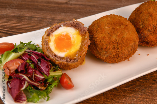 RECIPE FOR BREADED BEEF MEATBALLS STUFFED WITH A SOFT BOILED EGG. High quality photo