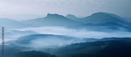 Majestic Mountains Rise Behind Serene and Foggy Hills © TheWaterMeloonProjec
