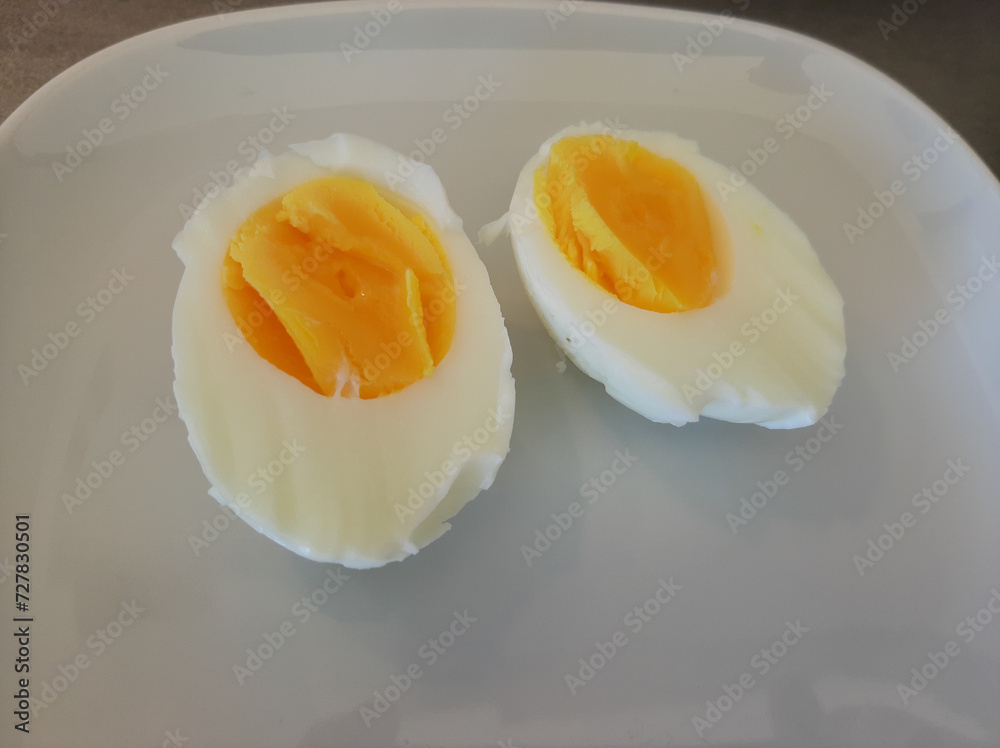 A boiled sliced egg arranged on a white plate A boiled sliced egg arranged on a white plate