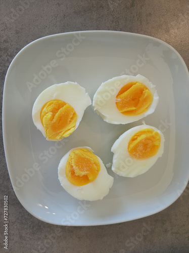 Two boiled sliced eggs arranged on a white plate