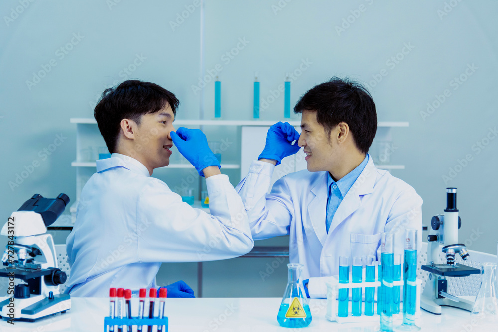 Two asian scientist men fist bump team partner shake hands together ...