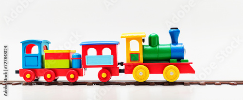 primo piano di coloratissimo trenino giocattolo in legno e rotaie su sfondo bianco photo