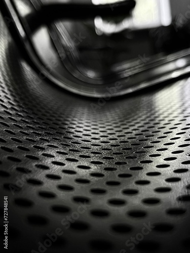close up of perforated steel seat in black and white