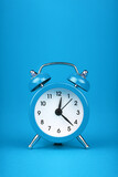 Close up one blue alarm clock over blue background