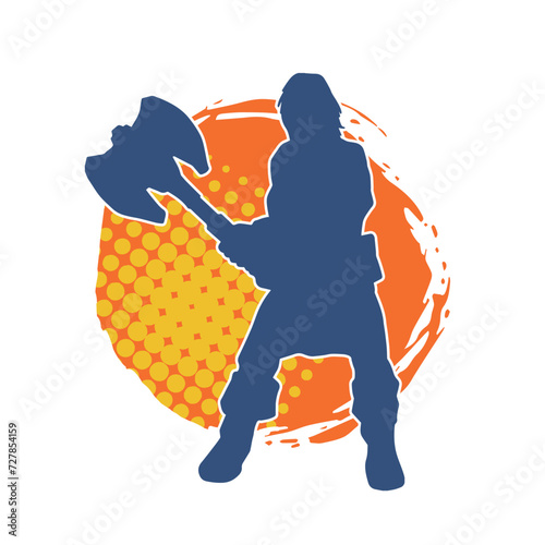 Silhouette of a male warrior carrying broad bladed war axe. Silhouette of a viking warrior with bearded axe weapon in action pose.
