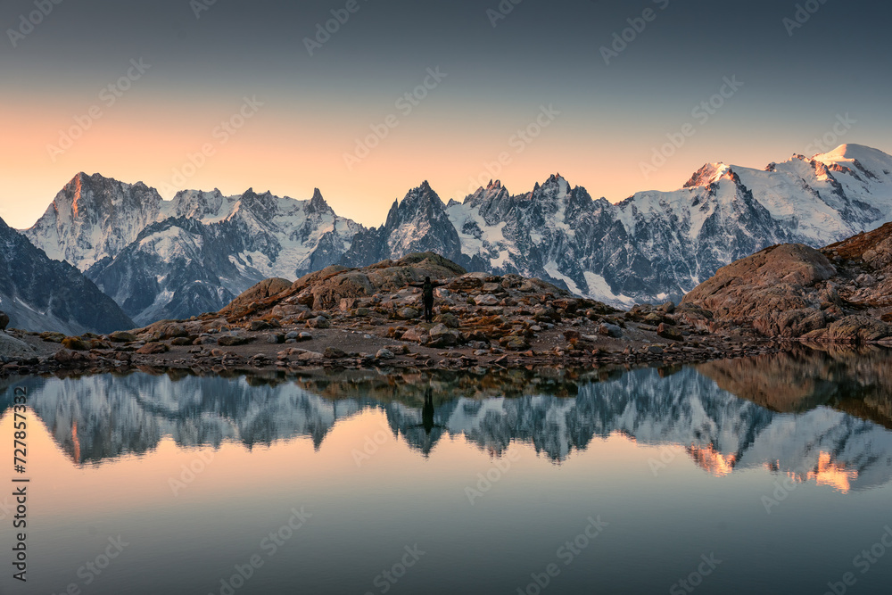 Lac Blanc with Mont Blanc mountain range and male tourist reflect on the lake in French Alps at Chamonix, France