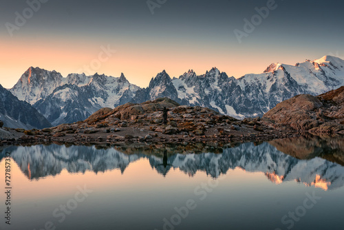 Lac Blanc with Mont Blanc mountain range and male tourist reflect on the lake in French Alps at Chamonix, France photo