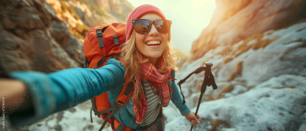 Energetic Female Hiker Captures a Selfie While Exploring Rugged Mountain Terrain at Golden Hour