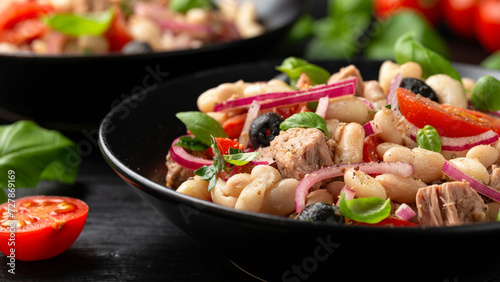 White bean tuna salad with olive, red onion, tomatoes. Healthy food photo