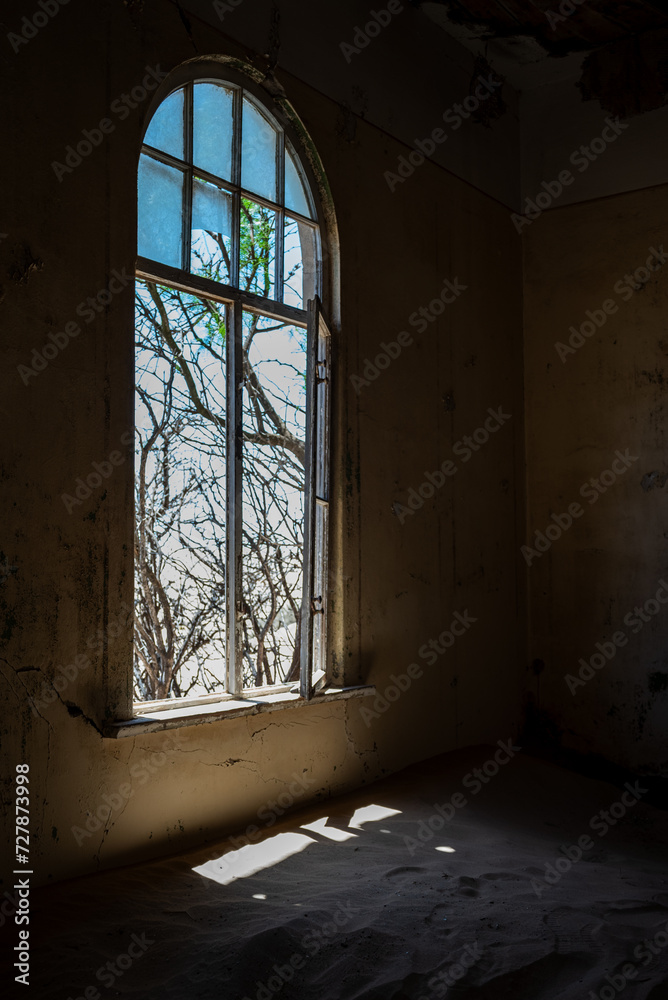 Abandoned interior space with an illuminated window in an old desert town Abandoned interior space with an illuminated window in an old desert town