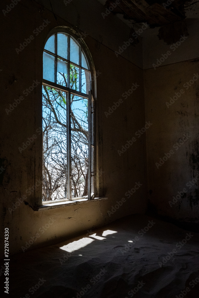 Aged, dilapidated room with a big window in an old desert town
