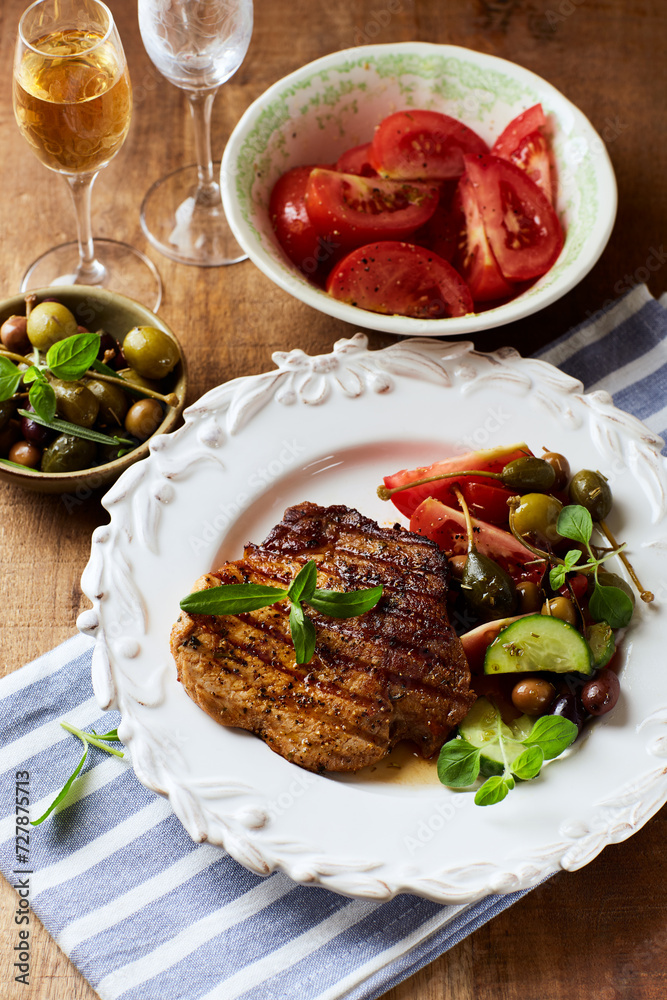 Grilled pork steak with fresh salad. Close up.
Grilled pork steak with fresh salad. Close up.