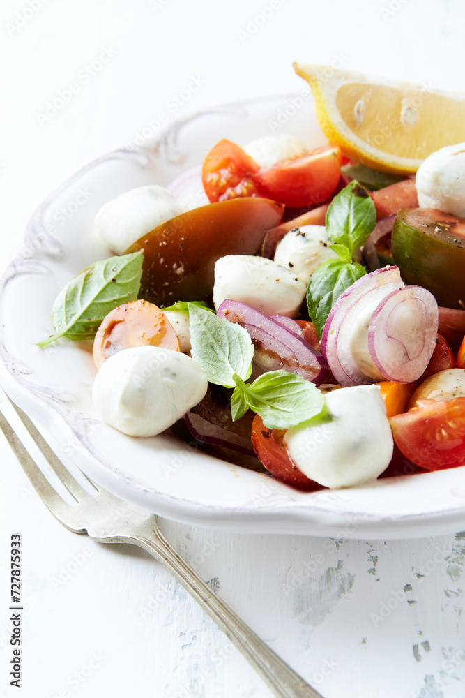 Summer Salad with Mozzarella Cheese, Tomatoes and fresh Basil. Bright wooden background. Summer Salad with Mozzarella Cheese, Tomatoes and fresh Basil. Bright wooden background.