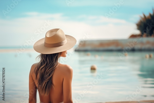 blonde girl with long hair and hat on summer holiday, on the seashore, lots of sunshine © JuanMa